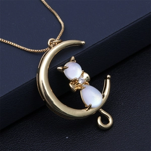 Golden crescent moon and opal fox necklace with sparkling stone on dark background