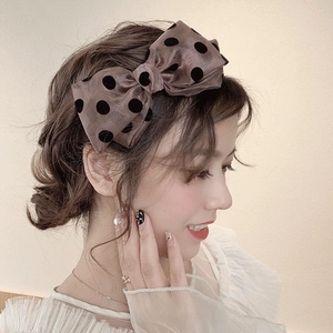 Elegant brown satin headband with black polka dots and sweet bow on female model