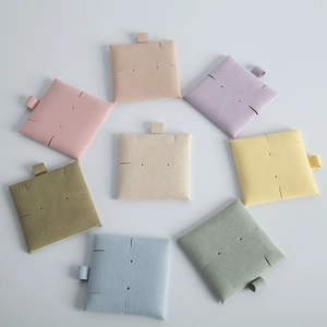 Square microfiber jewelry pouches in eight soft colors arranged in a circular array display