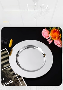 Close-up of polished stainless steel round serving plate with reflective mirror finish