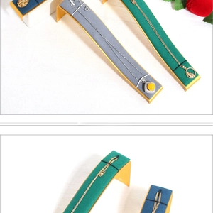 Macro detail of solid wood and velvet curved necklace display stands in multiple colors