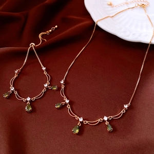 Detail von 18k Roségold-Set mit olivgrünen Birnen-Edelsteinen auf Seidenstoff