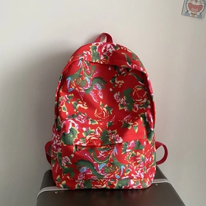 Detailed view of red floral canvas backpack featuring traditional peony and dragon patterns