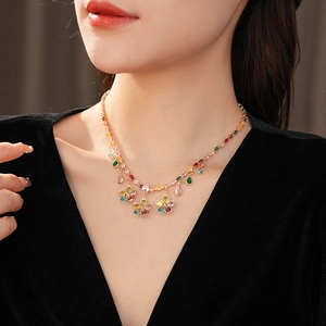 Detailed close-up of a gold necklace with colorful flower and teardrop zircon pendants