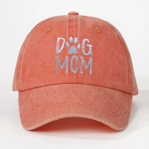Detail of orange washed cotton baseball cap featuring DOG MOM text and paw print logo