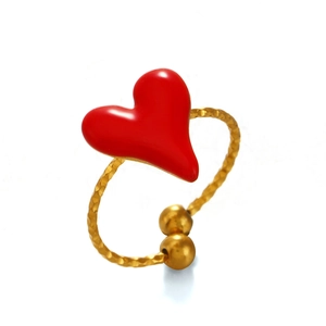 Minimalist gold heart ring with red enamel finish and hammered metal texture on white base
