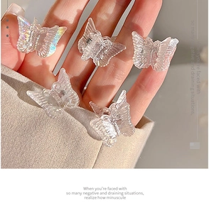Detailed close-up of five mini holographic butterfly hair clips held by hand