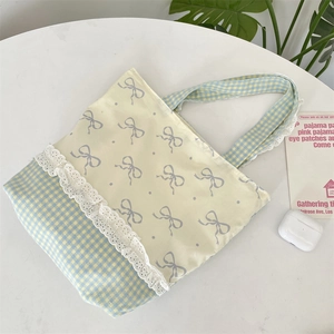 Detailed view of canvas tote bag featuring lace trim, blue check pattern and bow print