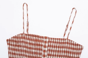 Detail of brown gingham top featuring smocked chest fabric and adjustable spaghetti straps