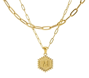 Detail of 18K gold double layer necklace featuring hexagonal M letter pendant and paperclip chain