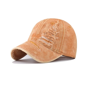 Detail shot of vintage washed orange cotton baseball cap with distressed rip effects