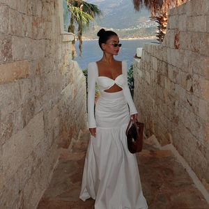 White long sleeve cutout maxi dress with cross waist design in a Mediterranean street setting