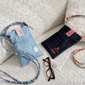 Detail of cute denim crossbody bags with rabbit and cherry embroidery and colorful beads
