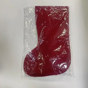 Flat lay of a red Christmas stocking gift bag packaged in a clear protective plastic sleeve