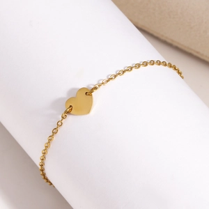 Gros plan d'un pendentif cœur doré minimaliste sur une chaîne de bijoux fine