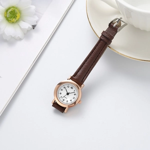 Detail of rose gold quartz watch with white dial and brown leather strap on white background