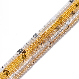 Close-up of gold, silver, and rose gold jewelry chains showing fine twisted link texture