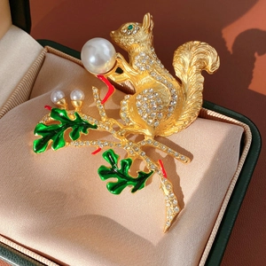 Détail de la broche écureuil vintage avec perles et strass sur un support doré