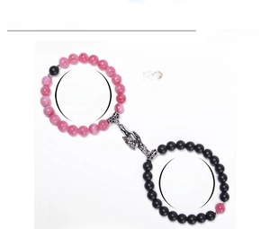 Detail of 8mm natural stone couple bracelets with magnetic hand-shaped connecting clasp