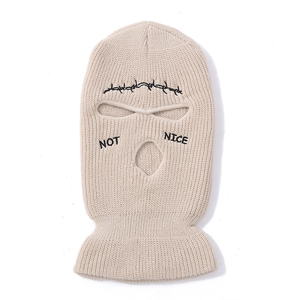 Detail of beige knitted balaclava featuring black Not Nice embroidery and wire pattern