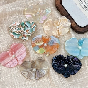 Elegant orchid shaped acetate hair clips with pearl details in various soft colors