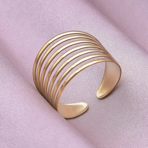 Macro detail of multi-layer golden stackable ring with brushed texture on silk