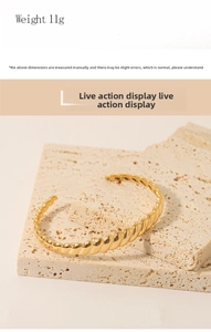 Detailed view of 18K gold plated spiral cuff bracelet weighing 11g on stone surface
