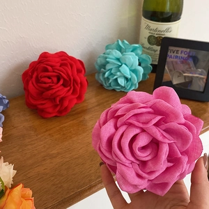 Close-up of a pink dried rose hair claw clip showing detailed fabric flower petals