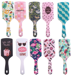Flat lay of multiple colorful printed air cushion hair brushes with soft massage tips