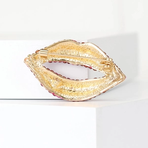 Back view of gold crystal lip brooch with red rhinestones and secure pin fastening