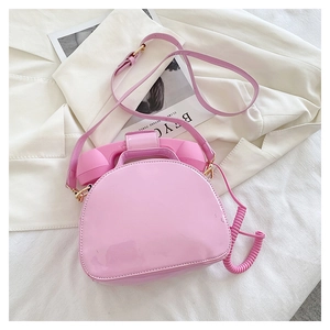 Detail of creative vintage telephone bag in pink patent leather with curly cord handle