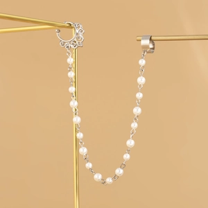 Detailed silver-toned butterfly ear-to-nose chain with elegant imitation pearls on a stand