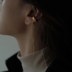 Elegant gold tassel ear cuff with minimalist stainless steel chains on model ear
