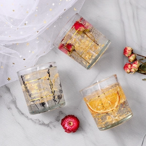 Aromatic jelly candles in glass jars with dried flowers and gold foil for romantic decor