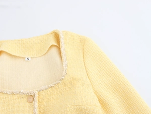 Close-up of yellow tweed dress with gold buttons, woven trim and size S neck label