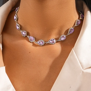 Détail du collier argenté avec pierres violettes en goutte d'eau et sertissage halo