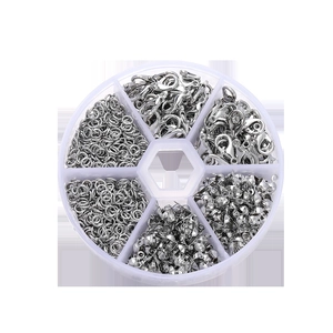 Macro view of silver lobster clasps and jump rings set in a clear round organizer box