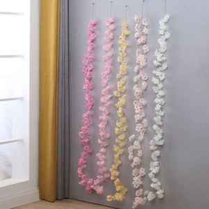 Close-up of five colorful silk cherry blossom vines in pink, yellow, and white shades