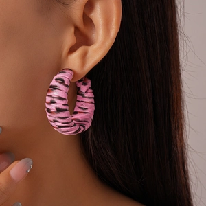 Detail of pink leopard print leather wrapped hoop earring shown on female model