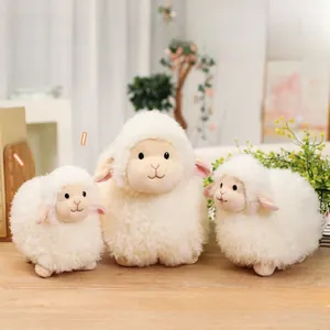 Three cute white plush sheep toys in large and small sizes on a wooden table