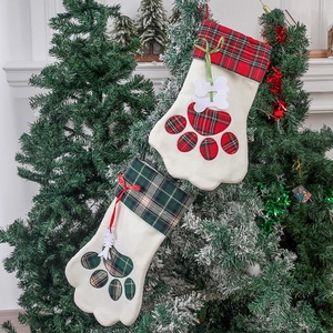 Paire de chaussettes de Noël en forme de pattes suspendues à un sapin festif décoré