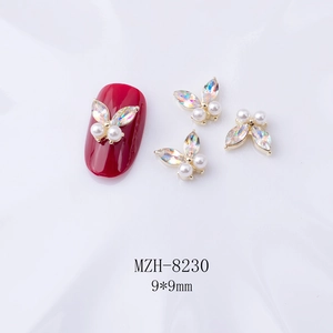 Détail de bijoux d'ongles papillon 3D avec perles blanches et ailes en strass brillant