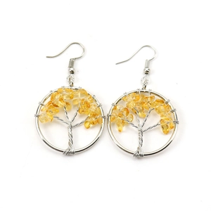 Macro view of handmade tree of life earrings with silver wire and yellow crystals