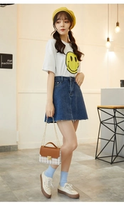 Chic plaid crossbody bag styled with a white graphic tee and blue denim skirt