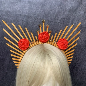 Detail of red satin roses and gold stars on a radiant sunburst halo crown headband
