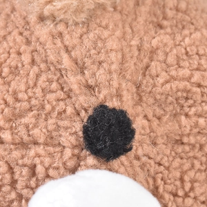 Macro shot of brown sherpa fleece texture and plush puppy ear detail on the cap