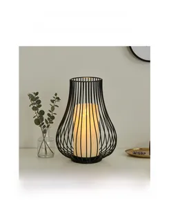 Detail of matte black iron hollow candlestick with warm LED candle on light stand