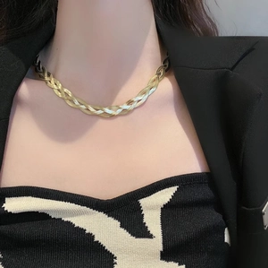Macro view of layered flat snake chain necklace with woven texture in 18K gold finish