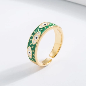 Detail of adjustable gold ring with green and white enamel evil eye patterns