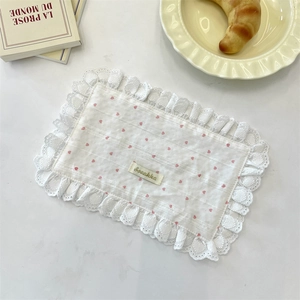 Detailed view of a white heart-patterned placemat with delicate embroidered lace edges